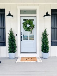 two potted plants are on the front porch