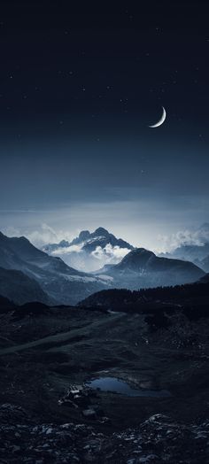 the moon is shining in the night sky over some mountains and valleys with low lying clouds