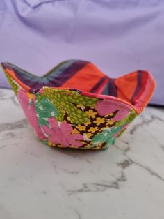 a small bowl sitting on top of a marble counter next to a purple cloth bag