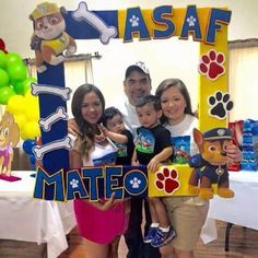 the family is posing for a photo in front of their dog themed birthday party sign