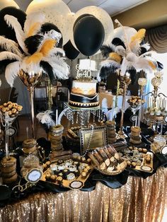 a table topped with lots of black and white desserts covered in gold sequins