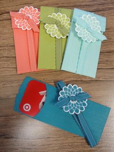 four different colored cards with bows and paper flowers on the top one is red, green, blue, yellow