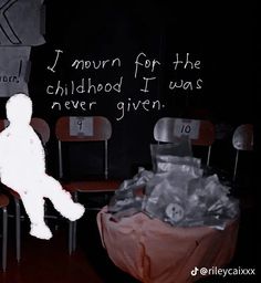 a child sitting on a chair in front of a chalkboard with words written on it