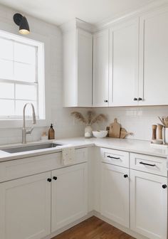 a kitchen with white cabinets and wooden floors