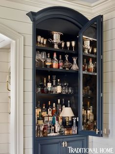 a cabinet with many bottles and glasses on it