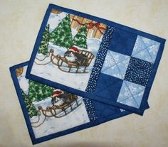 two quilted placemats sitting on top of a table next to each other