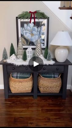 a table with christmas decorations on it in front of a stair case and framed photograph