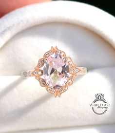 an engagement ring with a pink topaz surrounded by white and rose gold diamond accents