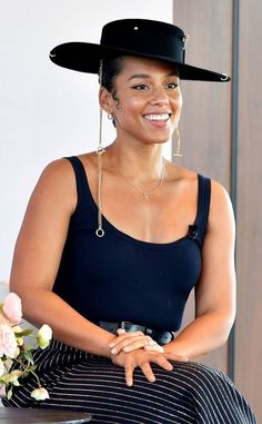 a woman wearing a black hat sitting on top of a table