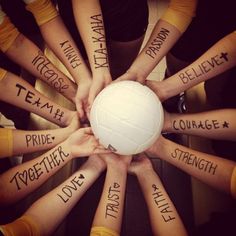 a group of people holding a white ball in the middle of their hands with words written all over them