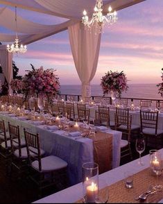 an outdoor dining area with tables and chairs set up for a formal function at dusk