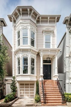 a two story house with stairs leading up to the front door