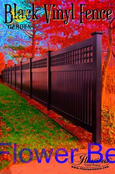 the black vinyl fence is in front of trees and grass with red leaves on it