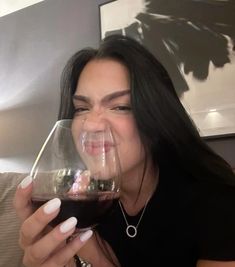 a woman sitting on a couch holding a glass of wine