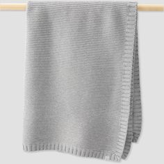 two gray knitted blankets hanging on a clothes line