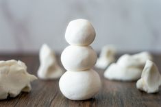 a pile of white marshmallows sitting on top of a wooden table next to each other