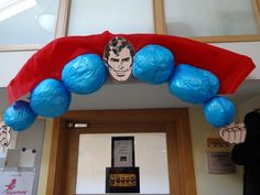 an arch decorated with blue and red paper mache balls is in front of a door