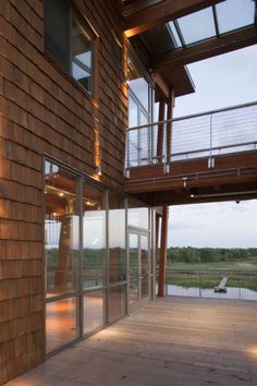 an outside view of a house with wood siding and glass doors that lead to the deck