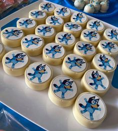 there are many cupcakes on the tray with blue frosting and cartoon characters