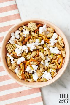 a bowl filled with cereal and marshmallows on top of a striped towel