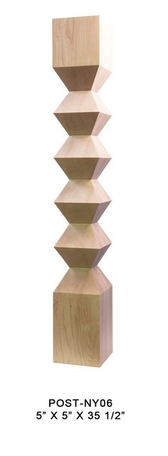 a tall wooden sculpture sitting on top of a white wall