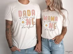 two people standing next to each other wearing matching tshirts that read dada and mama one beautiful