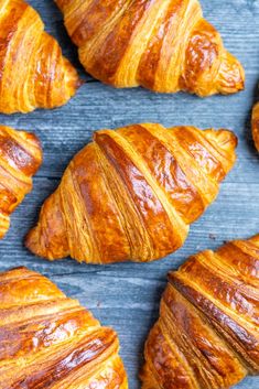 several croissants are arranged on a blue surface