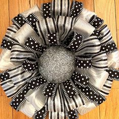 a black and white polka dot wreath on a wooden floor with silver sequins