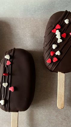 two chocolate covered pops with hearts on them