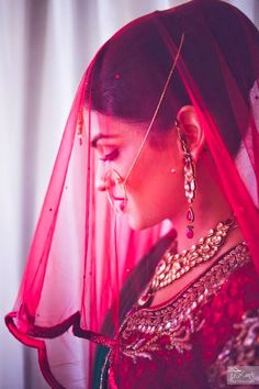 a woman wearing a red veil and jewelry