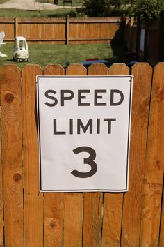 a speed limit sign posted on a wooden fence