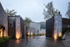 an outdoor courtyard is lit up at night with lights shining on the walls and doors