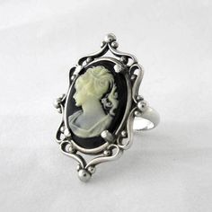 This ring features a 18 mm x 13 mm resin cameo set in a beautiful sterling silver frame ring and aged to resemble an antiqued heirloom. Due to the handmade nature of the creation, each piece may have slight variations. All items come with free resize and maintenance for the life of the product. Downloadable Ring Sizer Cameo Rings Vintage, Elegant Antique Silver Nickel-free Ring, Antique Silver Cameo Rings, Vintage Black Cameo Ring, Formal Silver Cameo Rings, Art Deco Silver Cameo Jewelry, Vintage Black Carved Rings, Vintage Black Carved Jewelry, Victorian Silver Cameo Rings