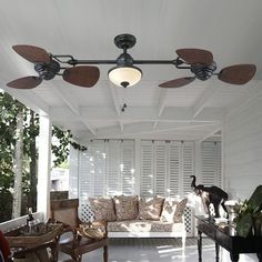 an outdoor living area with white walls and ceiling fans