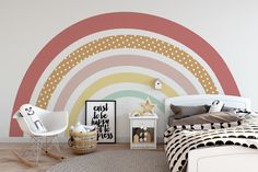 a room with a bed, chair and rainbow wall mural