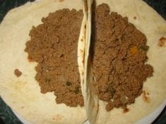 two burritos on a plate with meat filling