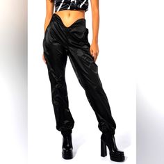 Serve Nothing But Net With The Akira Label Swish Swish High Rise Joggers! These Fresh Athleisure Bottoms Are Made From A Slick, Lightweight Fabrication And Feature A Curved High Rise Waist With An Elastic Back Band, A Skinny Leg Fit, And Cinched Elastic Ankle Hems. Pair This Sculptural Piece With A Crop Top And Chunky Sneakers To Complete Your Look. - 100% Polyester - Hand Wash Cold - 40.5” Waist To Hem - 29” Inseam (Approx. Measured From Size Small) - Model Is Wearing Size Small - Imported Alth Edgy Black Parachute Pants, Fitted Black Nylon Parachute Pants, Black High-waisted Parachute Pants With Elastic Waistband, Black Stretch High-waisted Parachute Pants, Black Stretch High Waist Parachute Pants, Trendy Fitted High Waist Parachute Pants, Fitted Black Nylon Pants, Trendy Black Parachute Pants For Sports, Black High-waisted Parachute Pants For Night Out