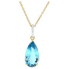 This gorgeous aquamarine and diamond necklace features a spectacular 8.28 carat pear-shaped aquamarine set in 18k yellow gold. The crystalline aquamarine is a top quality gemstone with superior bright blue color and exceptional brilliance! Aquamarines with such fine color are extremely rare. This beautiful gem is accented with a pretty 18k white gold bail that has been pave-set with .08 carats of diamonds. This necklace will transition easily between daytime and evening wear. Handcrafted by our Formal Yellow Gold Aquamarine Necklace, Pear-shaped Blue Topaz Necklace, Bright Blue Color, Jewelry Wardrobe, Aqua Marine, Yellow Gold Chain, Round Brilliant Cut Diamond, Bright Blue, Diamond Pendant