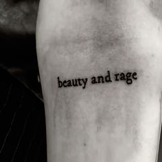 a person with a tattoo saying beauty and rage