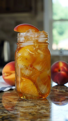 a mason jar filled with peaches sitting on top of a counter