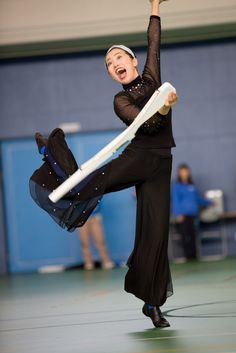 a woman in black dancing with a white frisbee