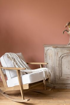 a rocking chair next to an old cabinet