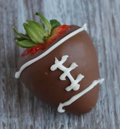 a chocolate covered strawberry sitting on top of a wooden table