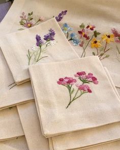 six embroidered napkins with flowers on them