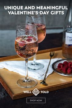 two glasses of wine and raspberries on a tray with the words unique and meaningful valentine's day gifts