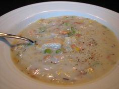 a white bowl filled with soup sitting on top of a table next to a spoon