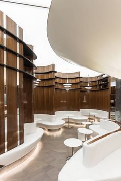 the interior of a modern office building with circular seating and wood paneling on the walls