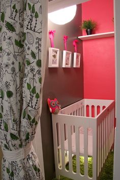 a baby's room with pink walls and green carpeted flooring, including a white crib