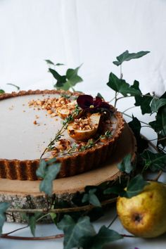 an apple tart sitting on top of a table next to some leaves and apples