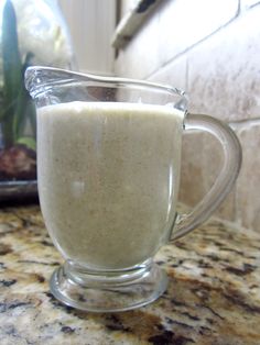 a glass pitcher filled with milk sitting on top of a counter